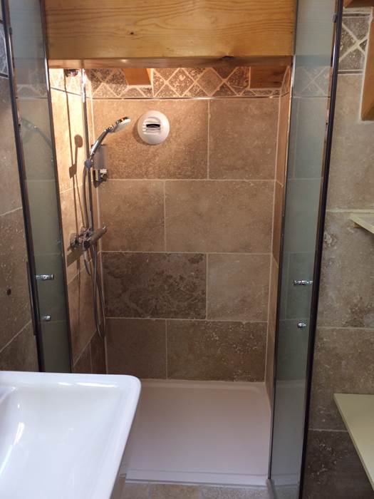 Intérieur de la douche italienne de 100x80 cm avec les porte du pare-douche ouvertes