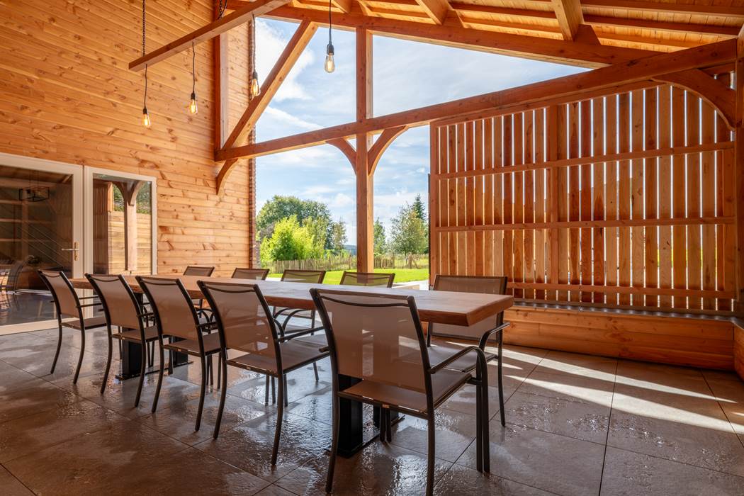 Terrasse couverte avec table en bois pour 10 personnes.