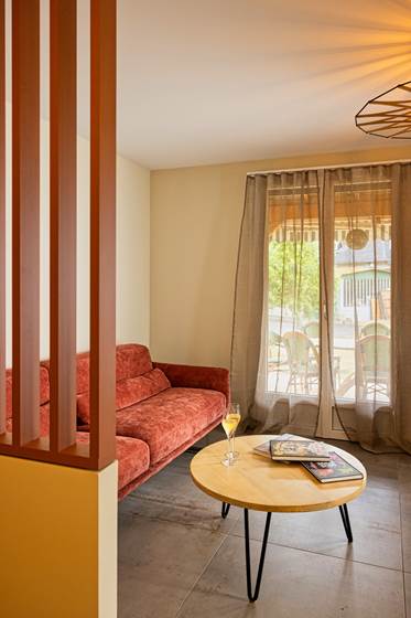 Le salon avec accès à la terrasse couverte et au jardin