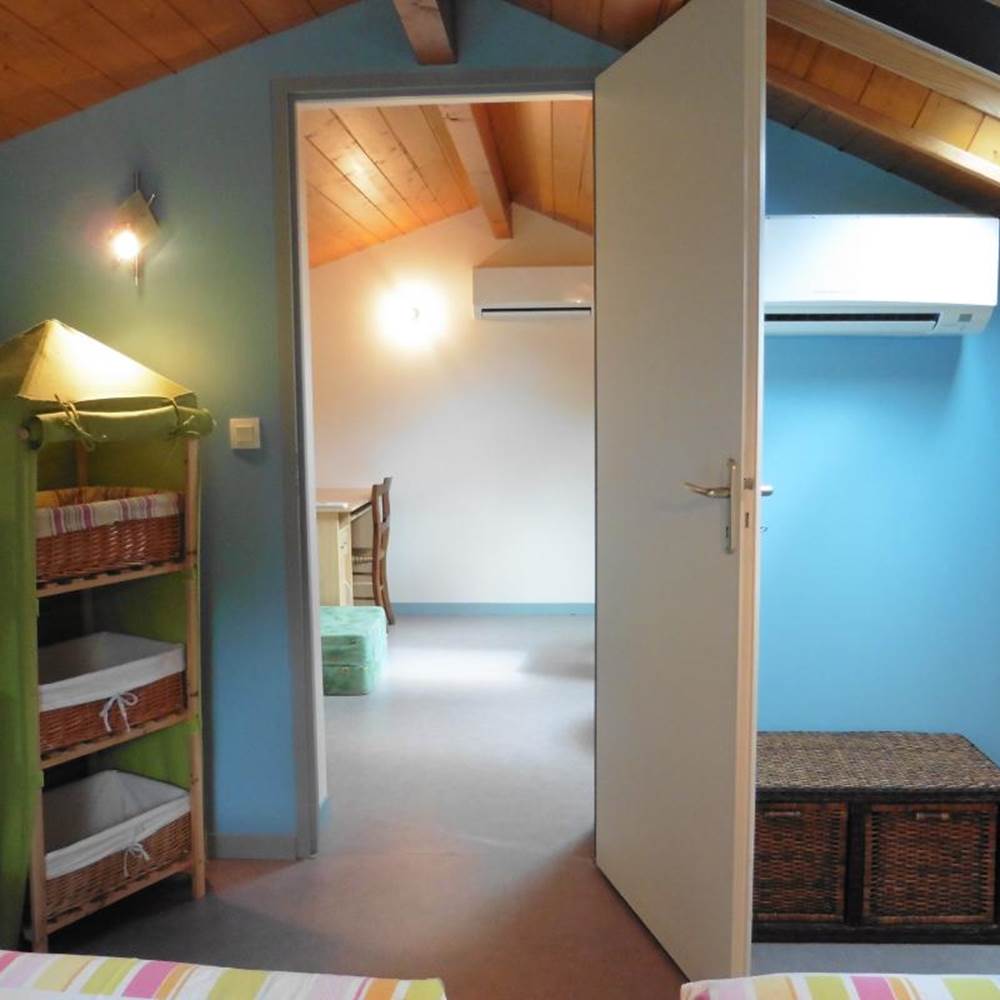 Chambre à l'étage du gîte avec 2 lits individuels donnant sur la mezzanine-presta