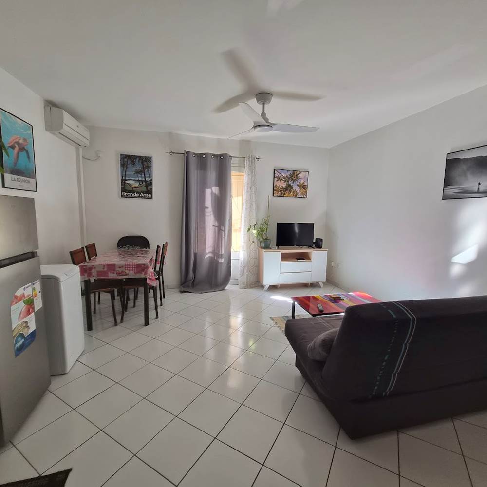 T2 Frangipanier climatiseur, séjour, vue d'ensemble, plaque de cuisson, table à manger
