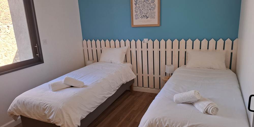 Chambre avec deux lits simples du gîte Le Pressoir à Montblanc, idéale pour enfants ou amis.