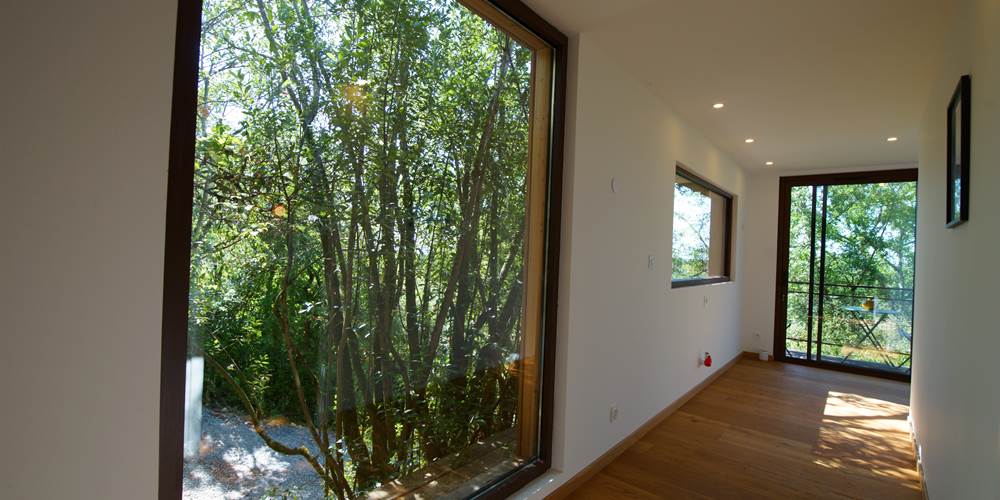 Grande baie vitrée vue sur les arbres