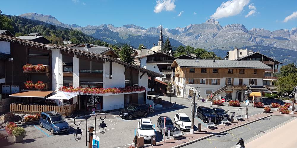 Vue du salon sur le syndicat du tourisme et  le parking .Chaines des ARAVIS derrière