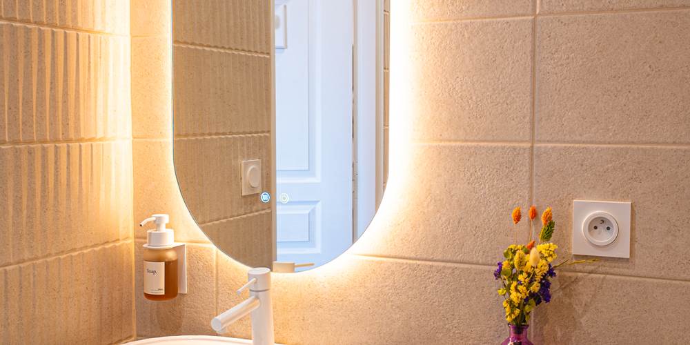 Des courbes et des lumières chaleureuses pour prendre soin de soi dans la salle de bain.