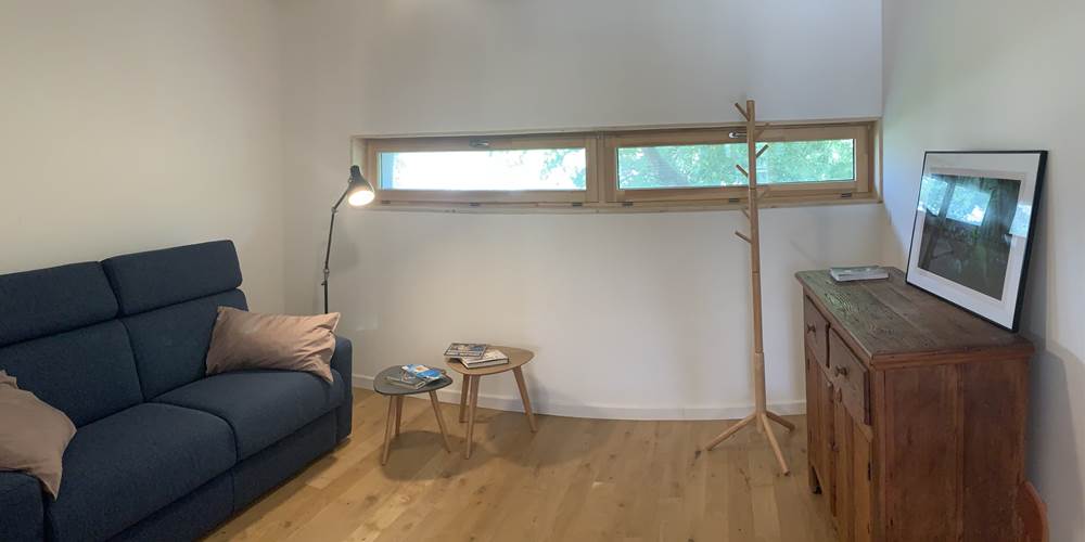 Espace salon avec un canapé, des tables basses, une commode et des chaises. L'endroit parfait pour se détendre.