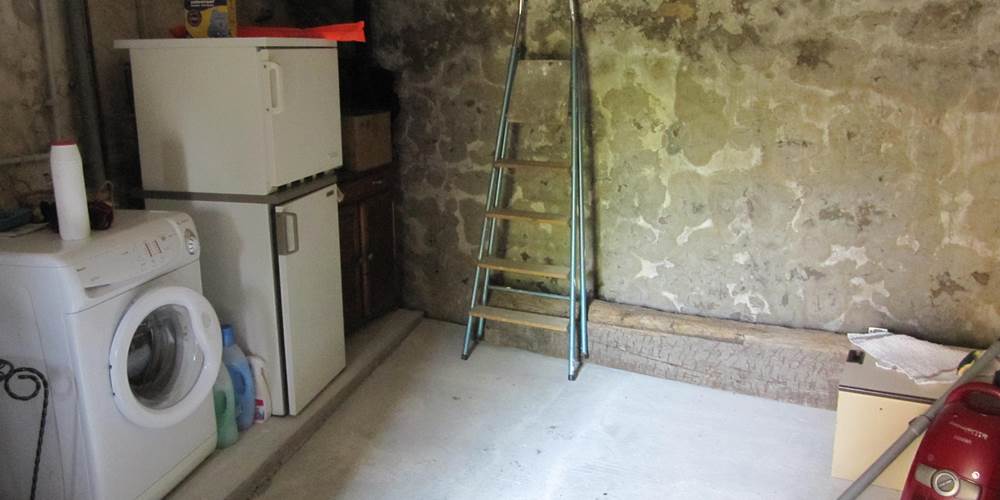 Une cave avec le lave linge, frigidaire, congélateur...