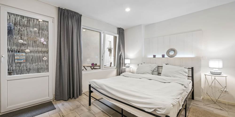 Slaapkamer met dubbelbed en privé terras