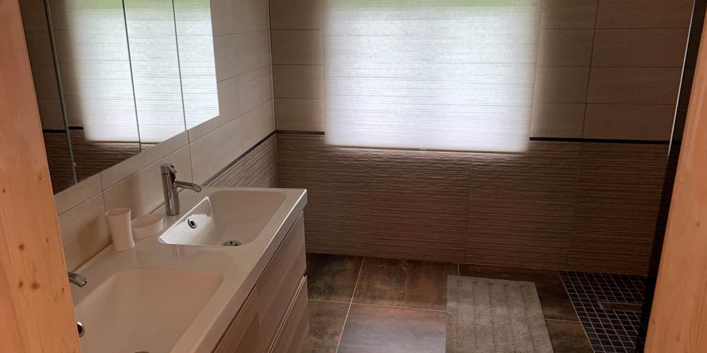 Salle de bain privative attenante à la chambre orange avec douche à l'italienne, pratique et confortable pour les séjours en groupe dans notre gîte rural du Pas-de-Calais.