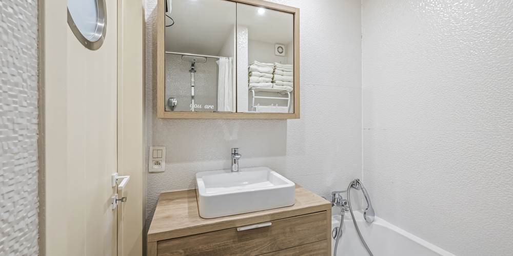 Badkamer met bad en douche en lavabo