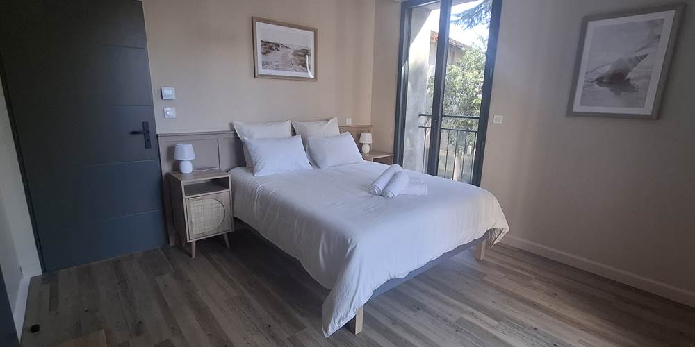 Suite parentale du gîte Le Pressoir à Montblanc, lit double et espace lumineux.