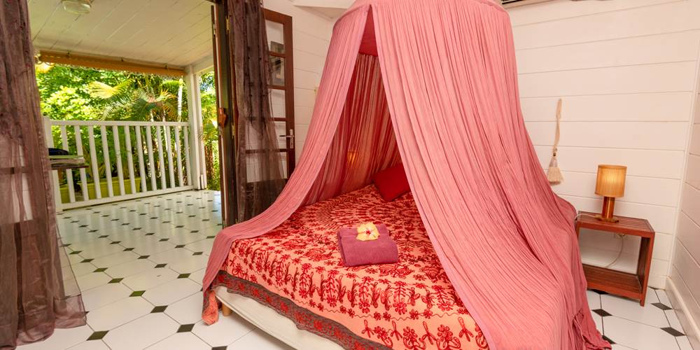 Chambre avec moustiquaire du gîte Ylang 1, décoration créole colorée, location Baobab et Palmiers La Réunion