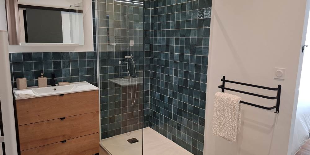 Salle de bain moderne du gîte Le Pressoir à Montblanc avec douche à l’italienne.