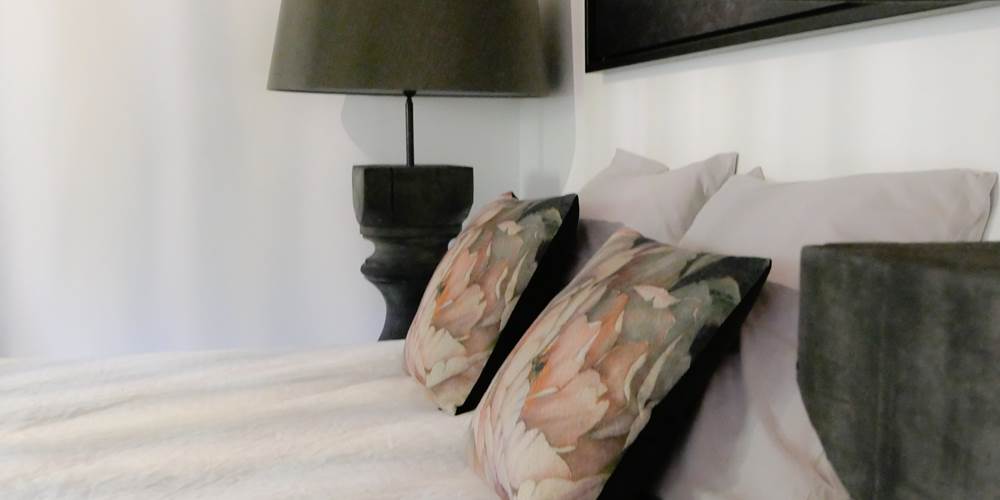 Une belle chambre à l’étage avec lit king size, coin détente et imposante lampe de chevet qui apporte une touche de caractère et une ambiance chaleureuse, idéale pour des nuits tout en douceur.