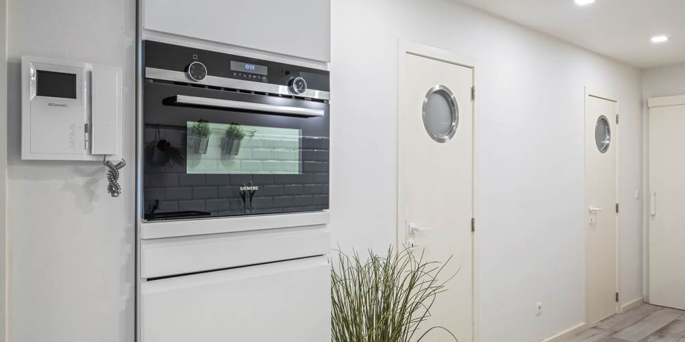 Keuken met oven en deuren naar badkamer en toilet