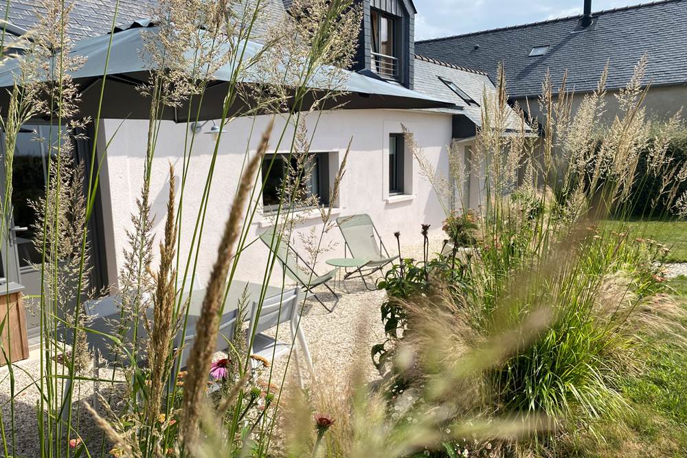 Une ouverture directe du salon sur la terrasse et le jardin, idéale pour les moments de détente.