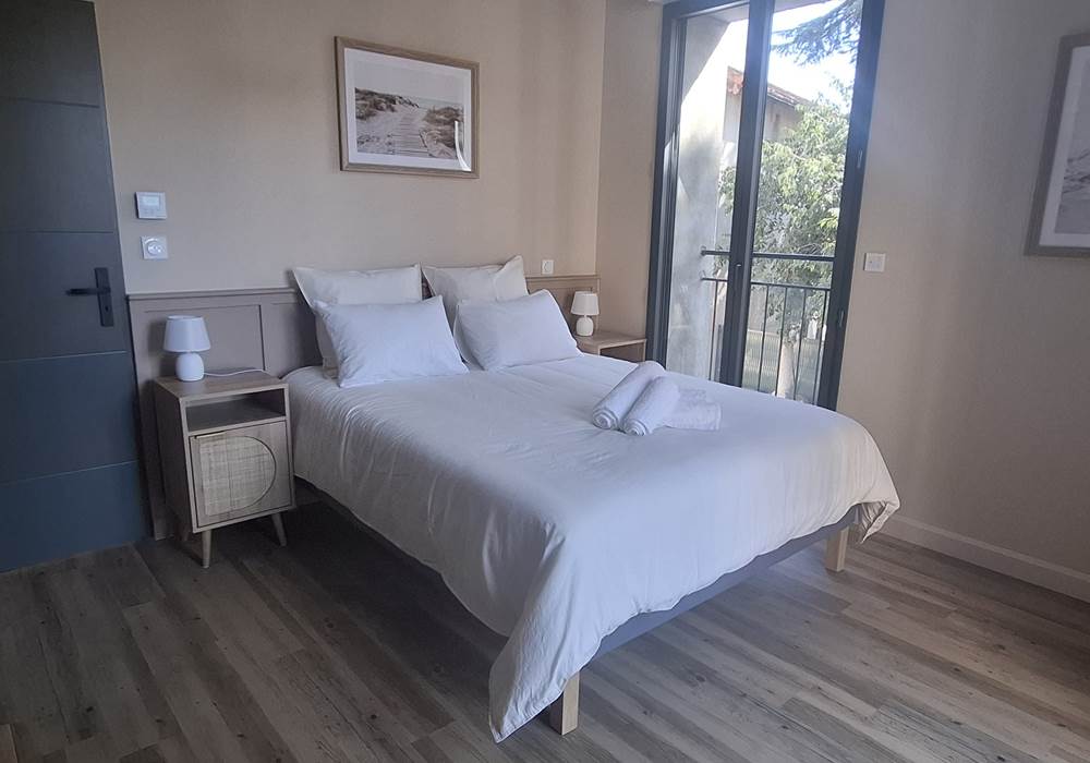 Suite parentale du gîte Le Pressoir à Montblanc, lit double et espace lumineux.