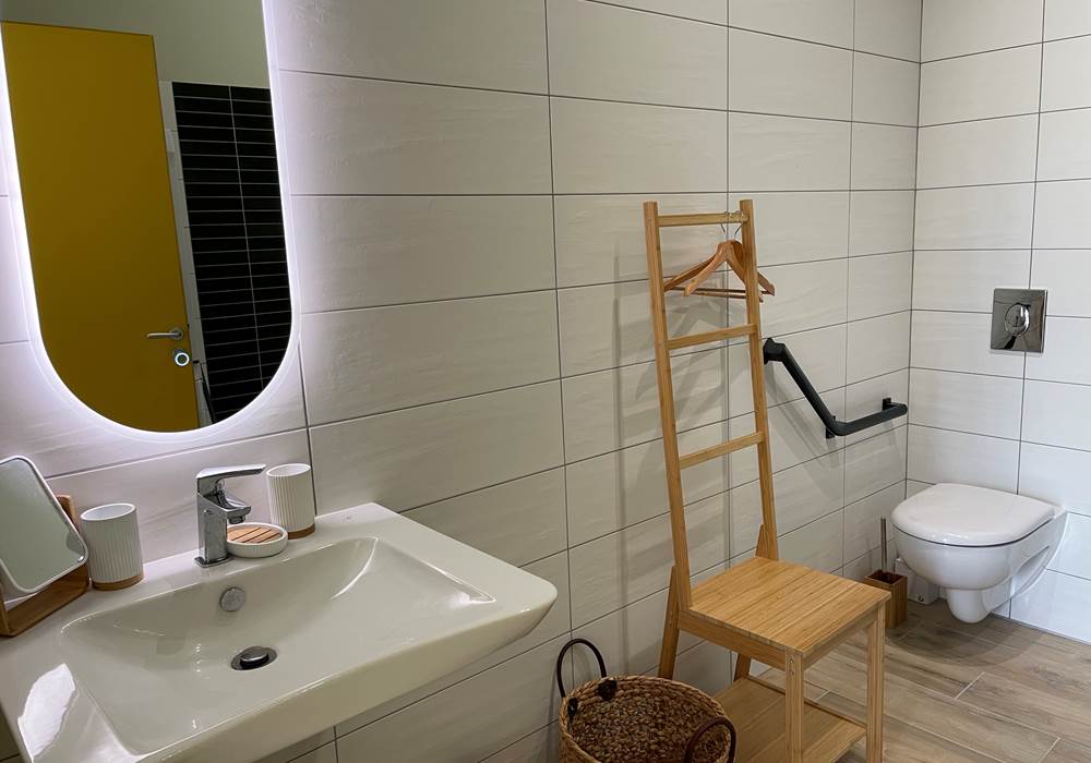 salle de bain principale accessible PRM avec grande douche, lavabo et WC
