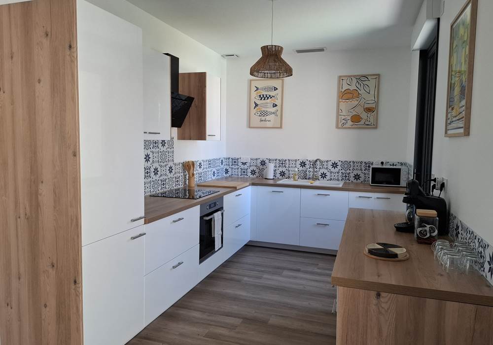 Cuisine entièrement équipée du gîte Le Pressoir à Montblanc, moderne et fonctionnelle.