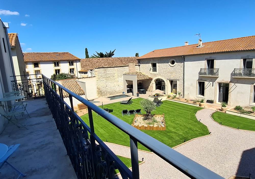 Vue sur le jardin du gîte Le Ramonetage depuis le balcon.