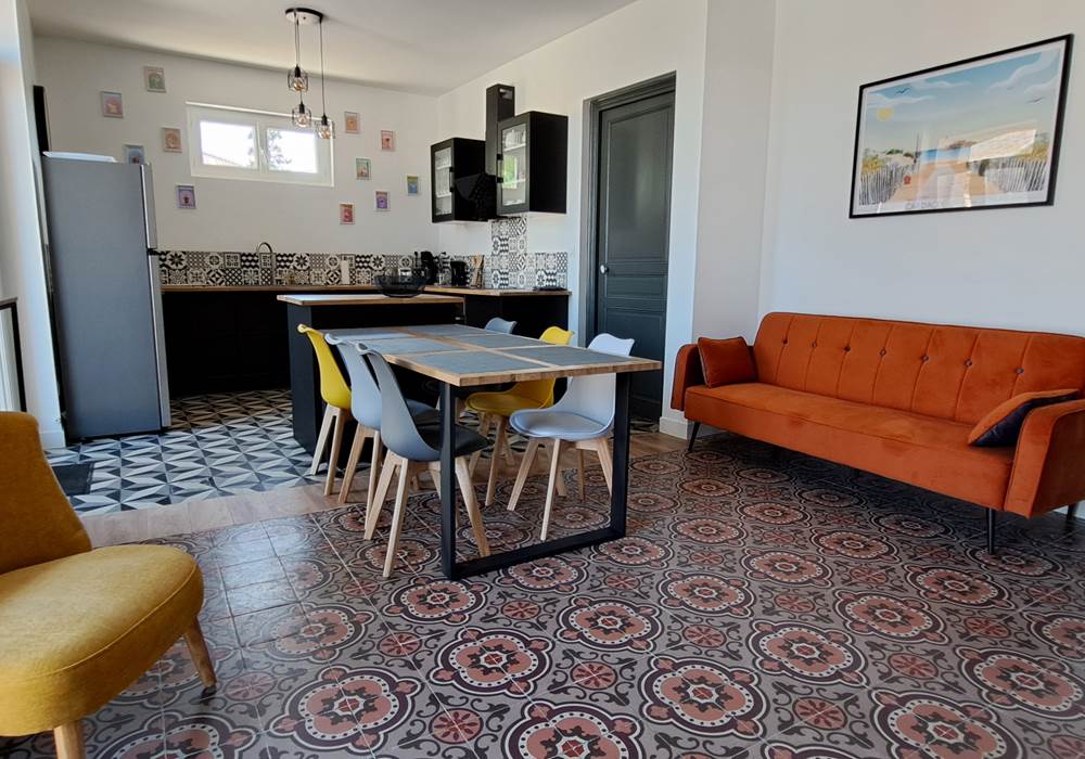 Séjour du gîte Le Ramonetage avec coin salon et coin repas.