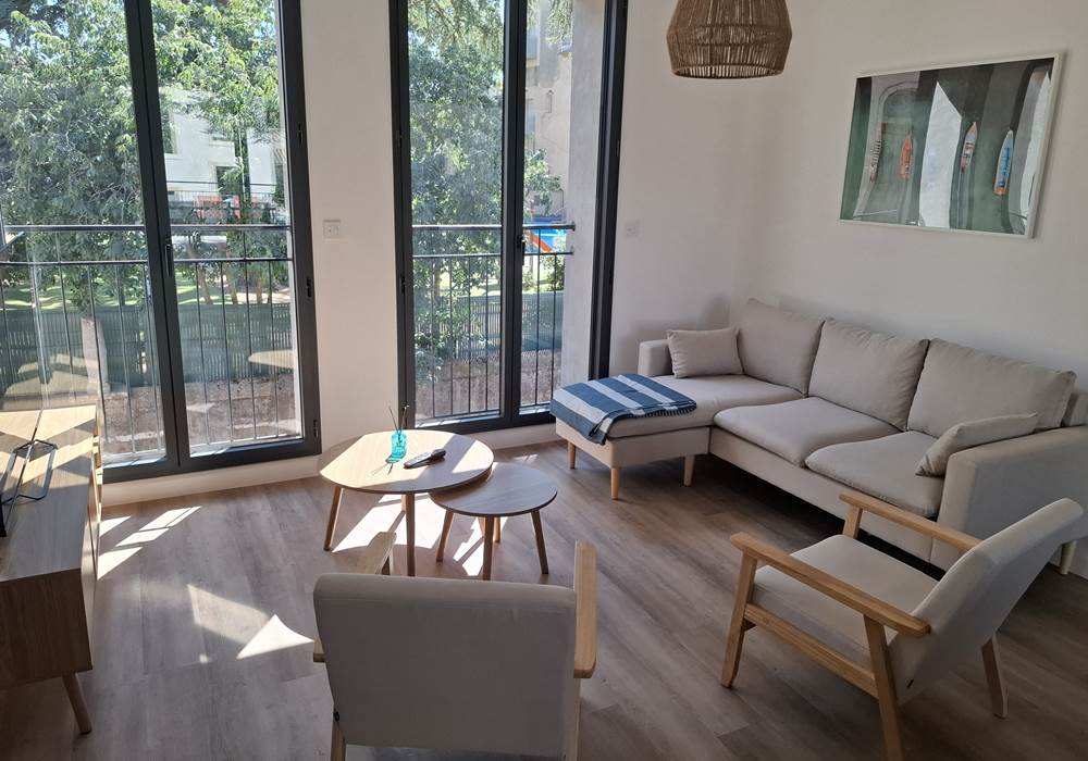 Salon confortable avec vue sur la terrasse – gîte Le Pressoir.