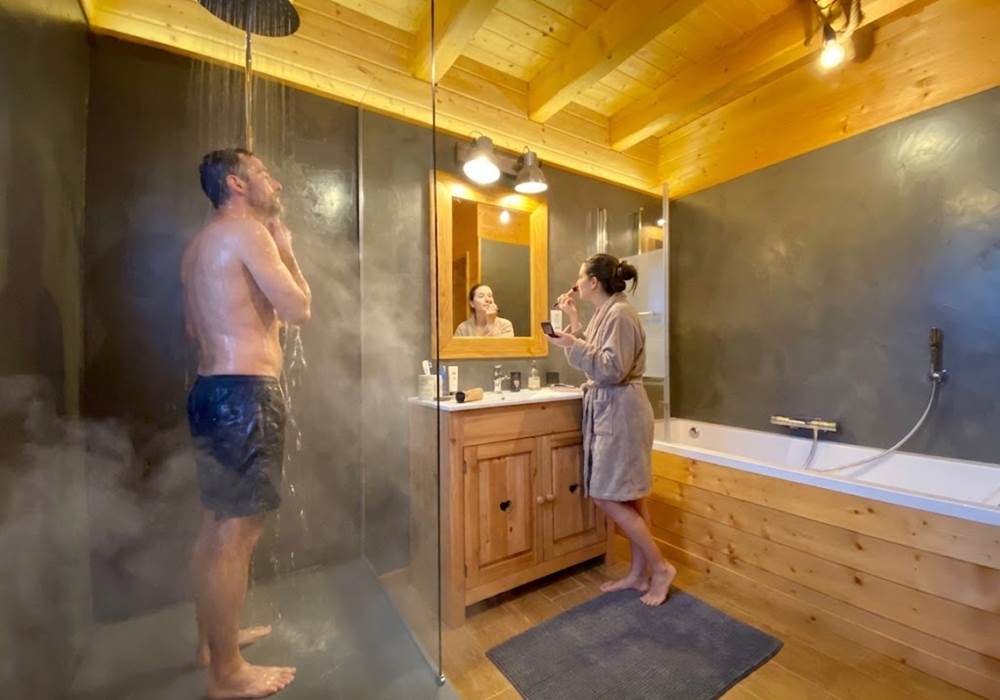Grande salle de bain avec douche à l'italienne et baignoire balnéo