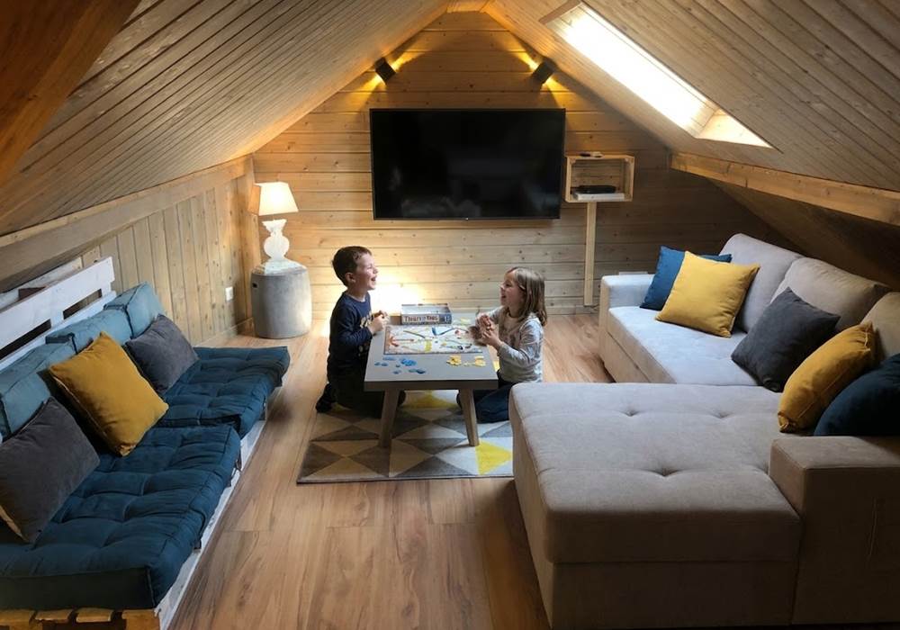 Salon à l'étage avec grand écran et canapés lits