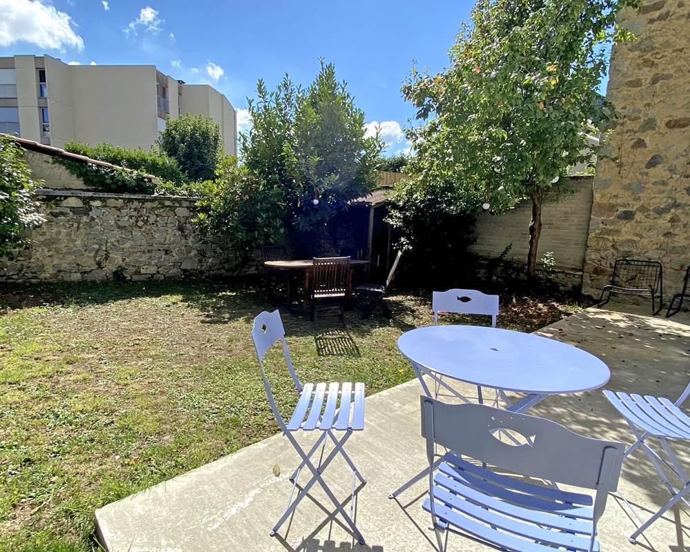 Jardin paisible avec terrasse, offrant intimité et confort pour vos repas ou moments de détente à Limoges.