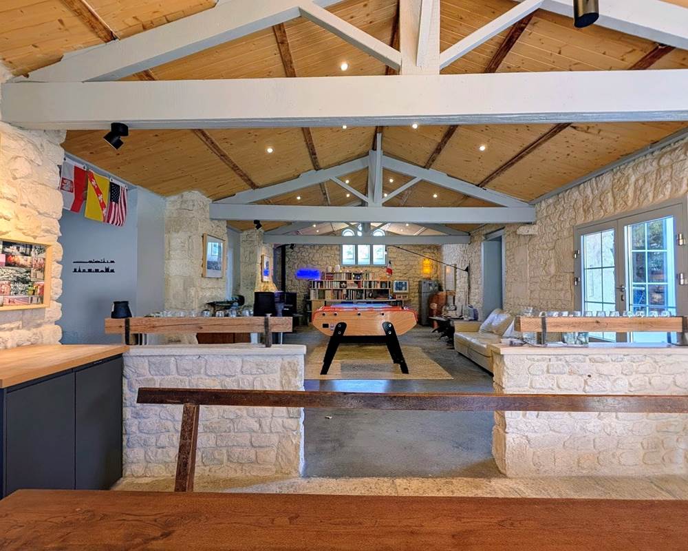 Salle de jeux avec baby-foot, ping-pong, bibliothèque et poêle à granulés