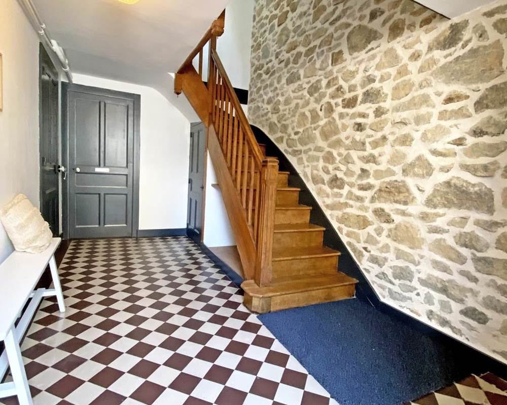 Entrée avec charme ancien, carrelage d’époque et escalier bois