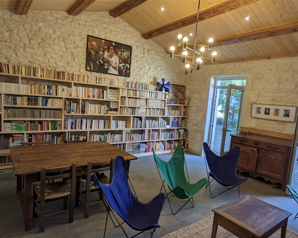 Salon avec bureau, TV, bibliothèque, jeux et cheminée