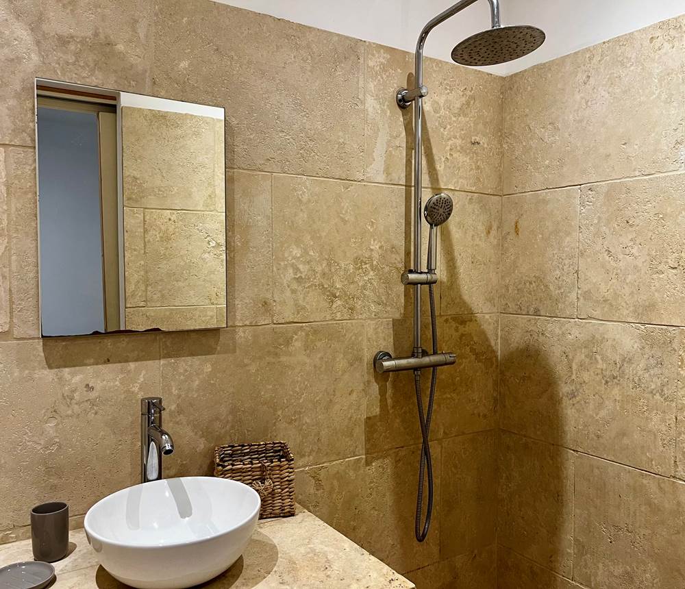 Salle de bain élégante avec douche à l’italienne, alliant confort et raffinement.