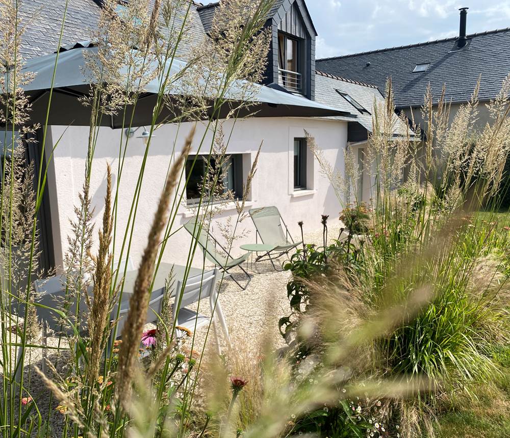 Une ouverture directe du salon sur la terrasse et le jardin, idéale pour les moments de détente.