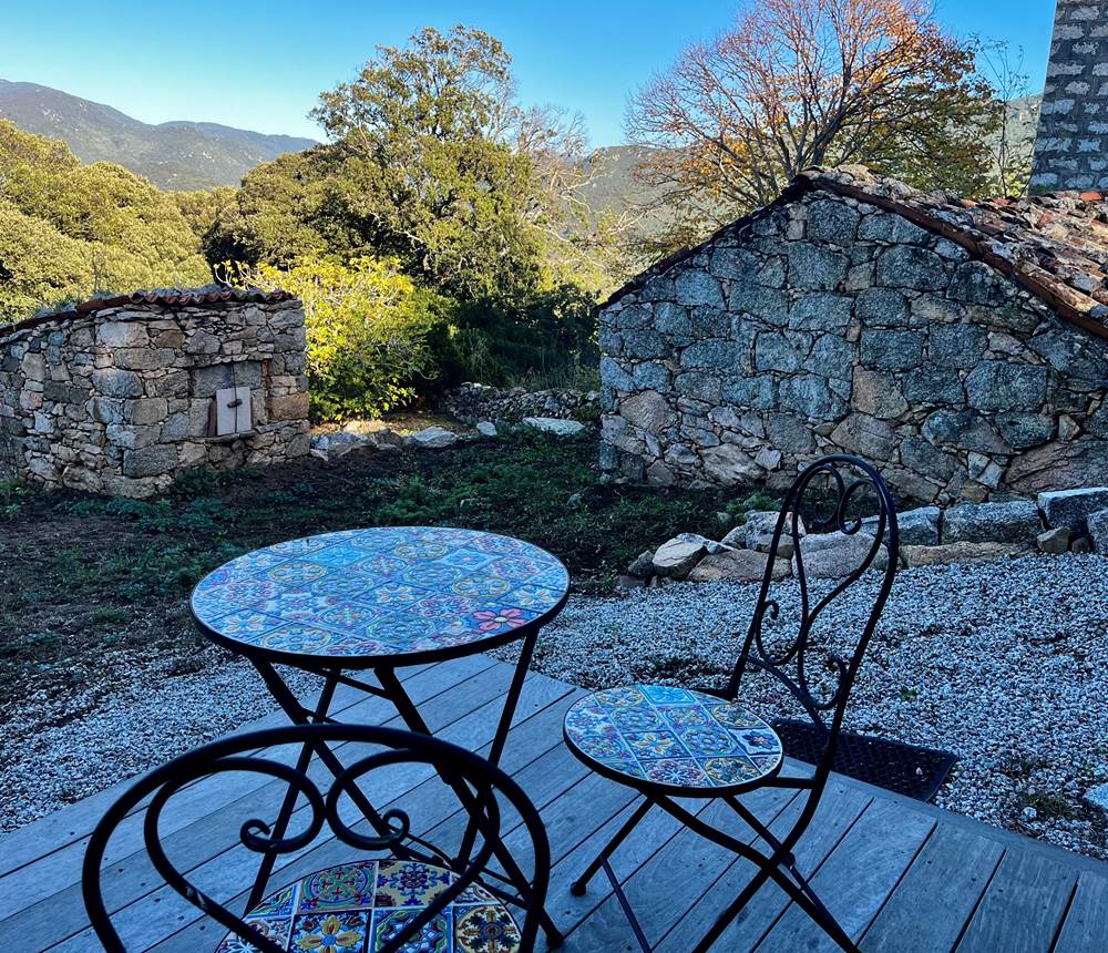 Charmante terrasse en pierre avec vue sur la nature, parfaite pour un moment de calme.