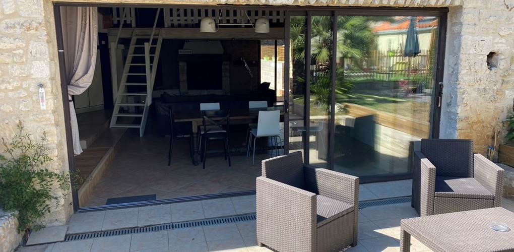 Salon extérieur avec grande baie vitrée donnant dans l'espace séjour