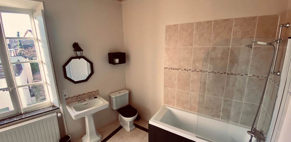 La salle de bain avec baignoire
