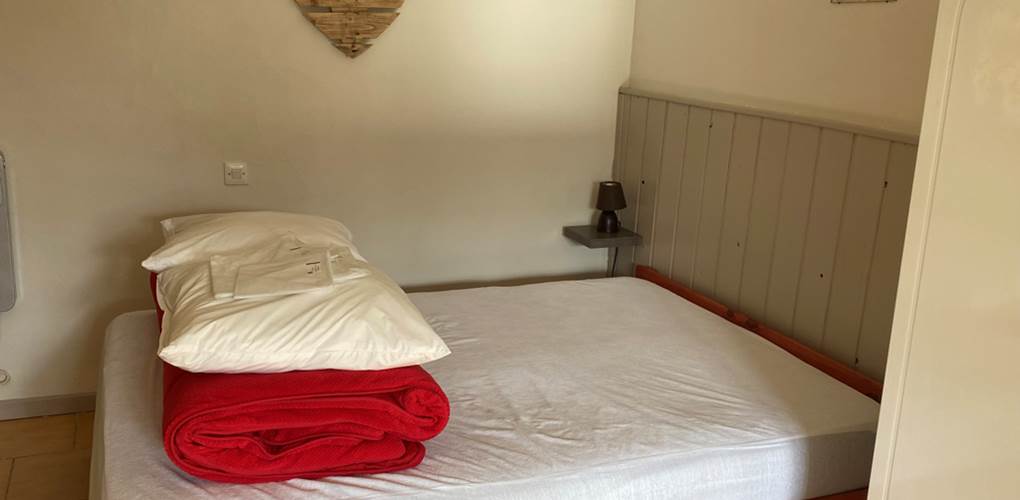 Pièce salon et chambre - vue du lit de 140cm