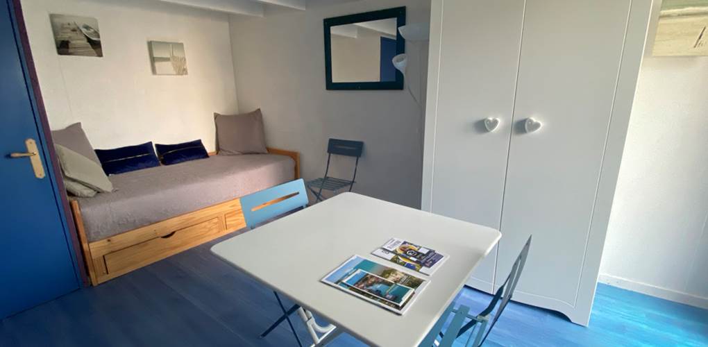 Espace salon séjour avec 1 lit gigogne formant un lit de 180cm et servant de canapé