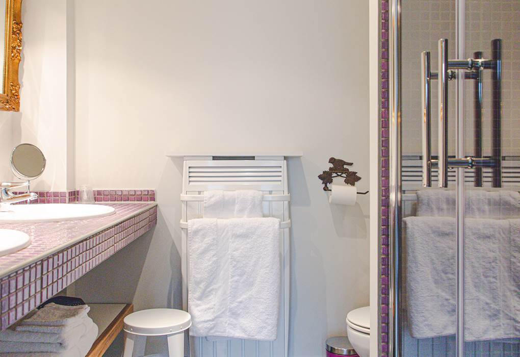 Une salle de bain au charme unique, avec une douche et deux vasques, habillée d'une mosaïque raffinée.