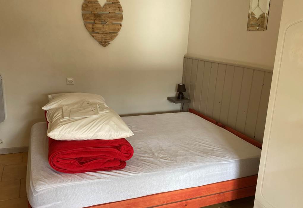 Pièce salon et chambre - vue du lit de 140cm