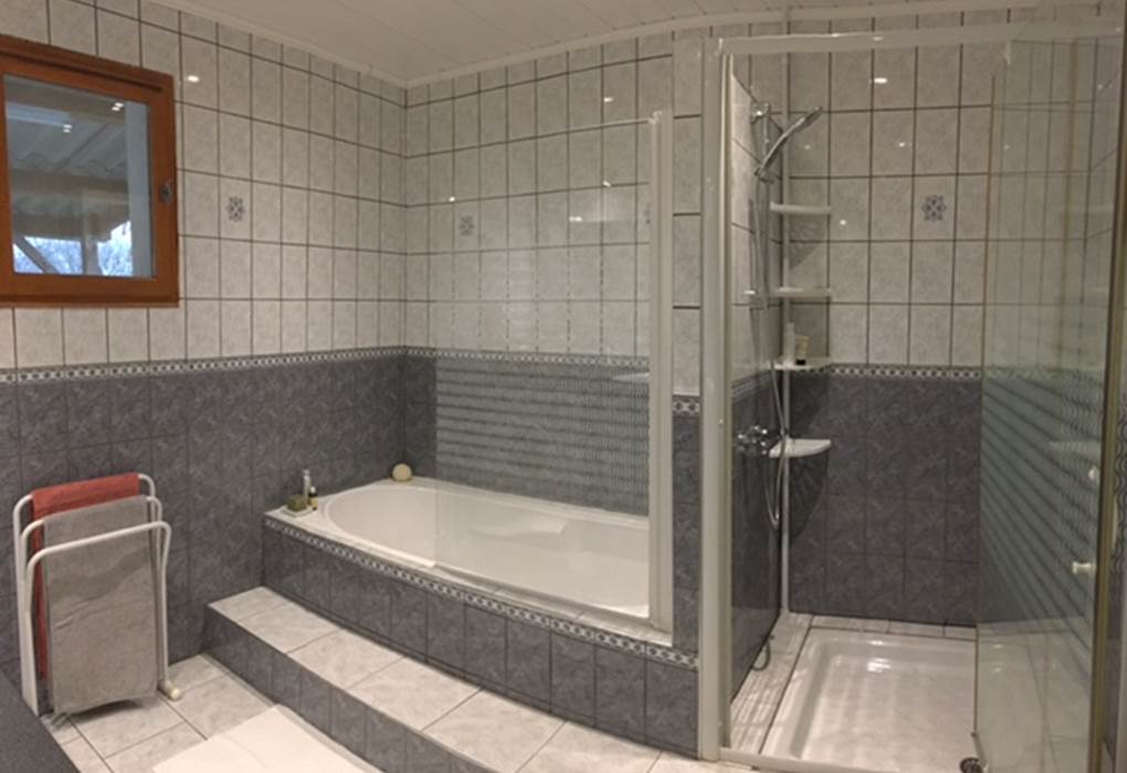 Salle-de-bain avec sa baignoire et sa douche