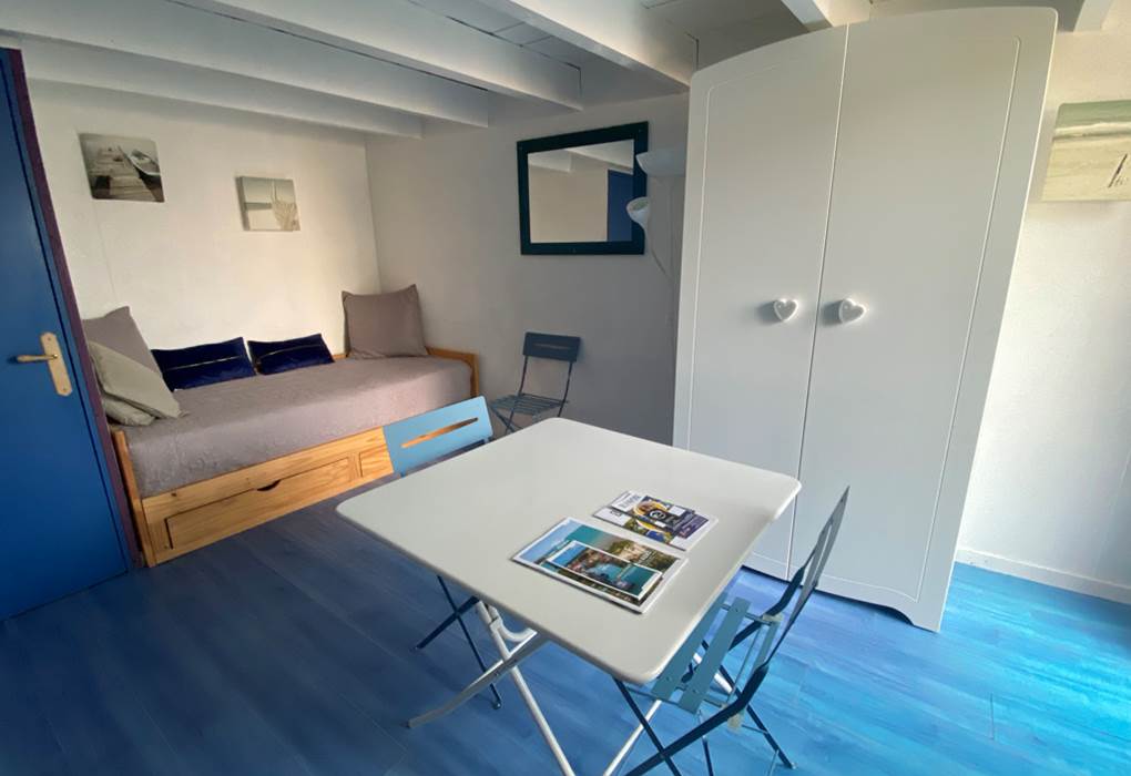 Espace salon séjour avec 1 lit gigogne formant un lit de 180cm et servant de canapé