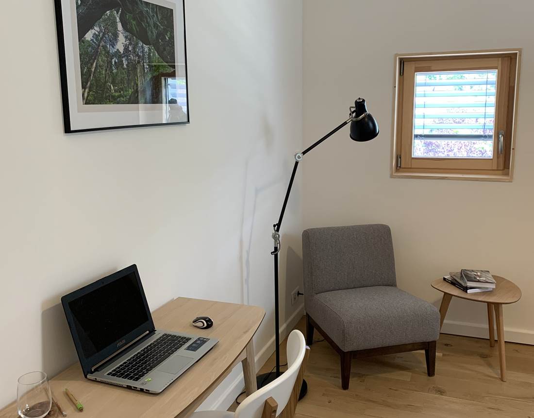 Coin cosy composé d'un petit bureau et sa chaise, d'un fauteuil confortable et d'une table basse.