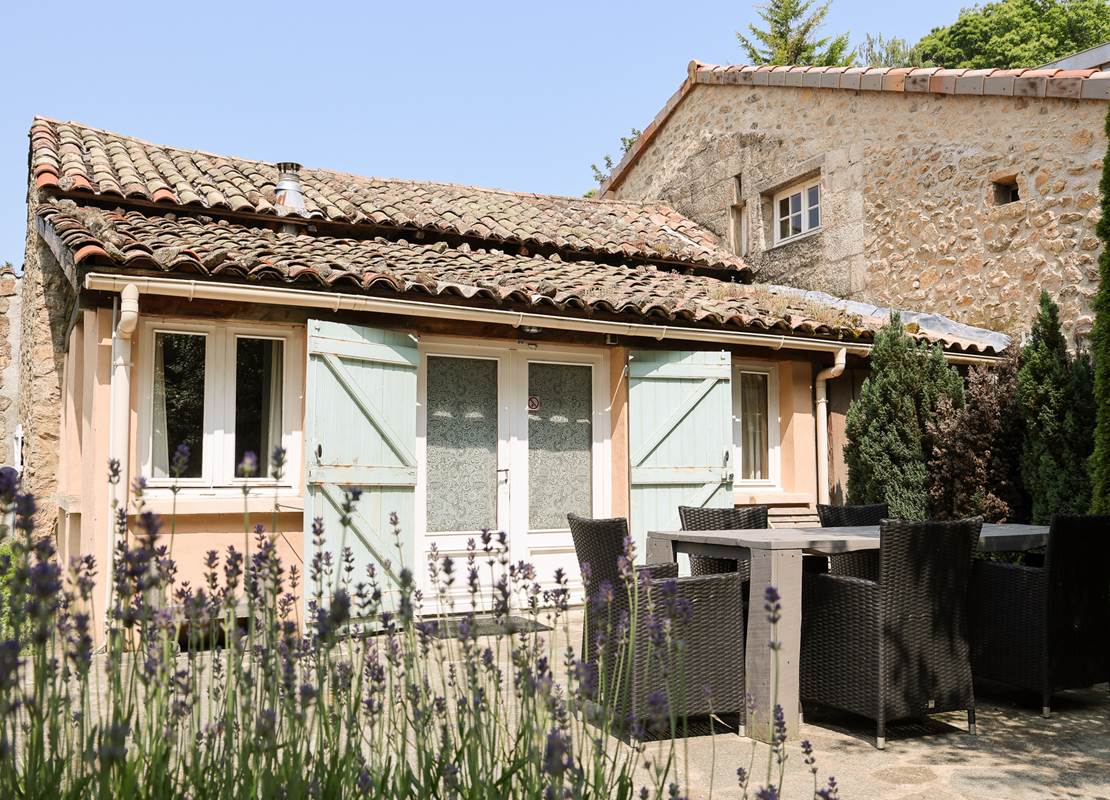 Grande terrasse face à la forêt avec table, chaises et hamac