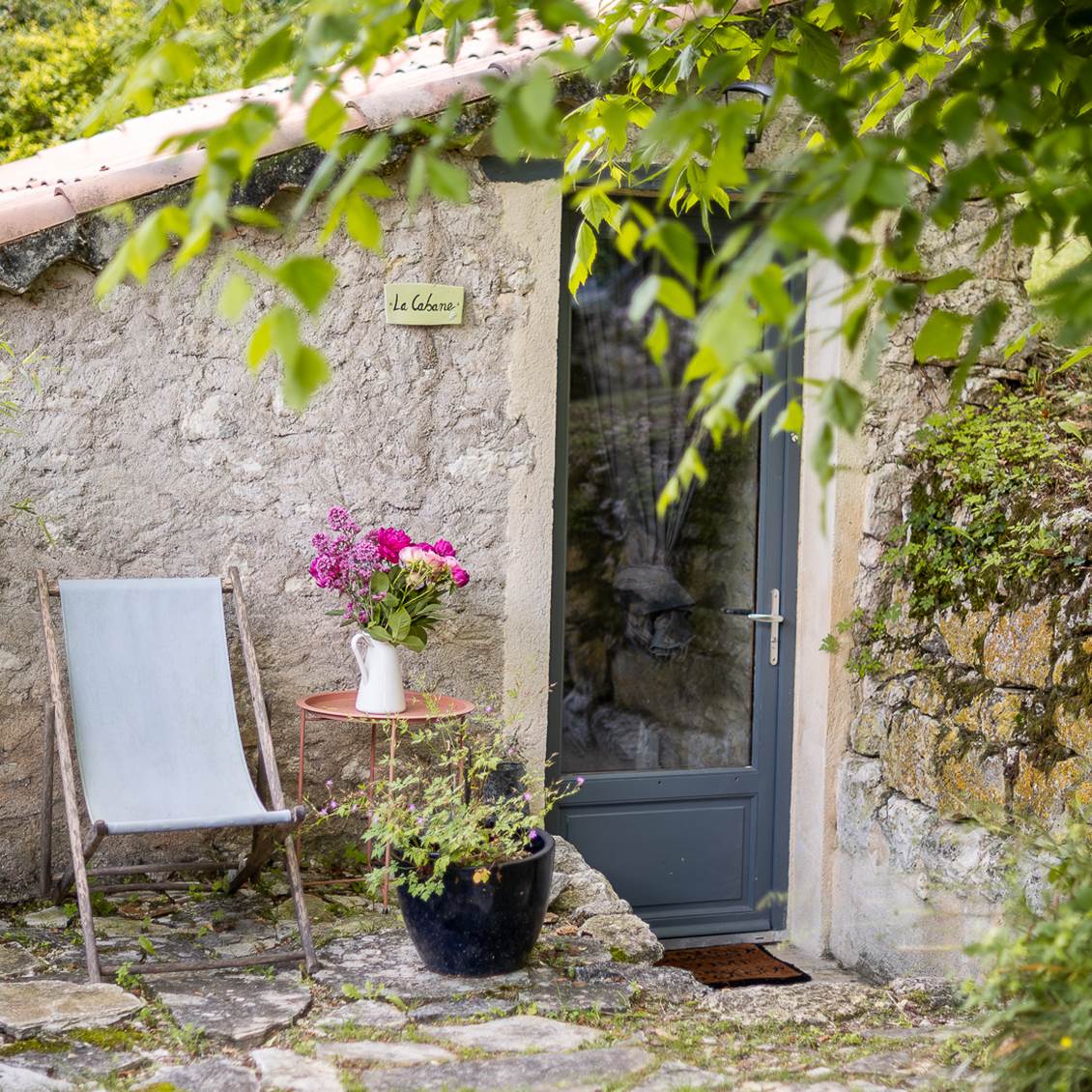 Façade en pierre de la Cabane avec coin détente extérieur