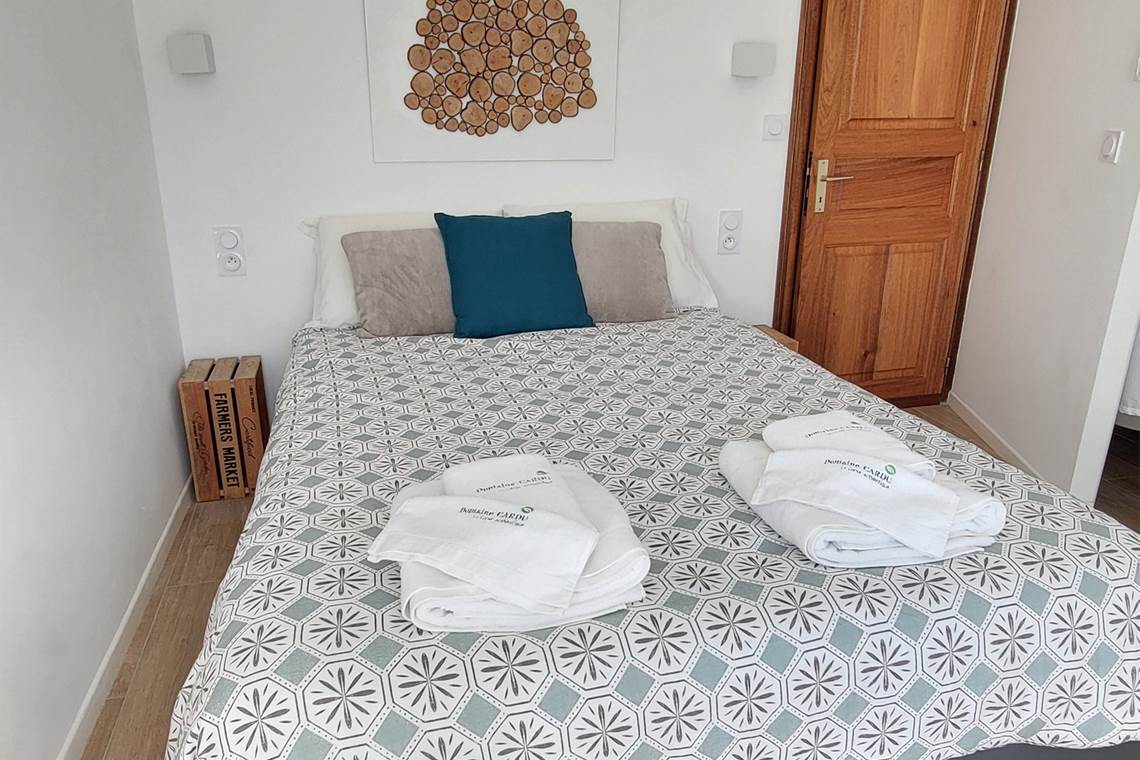 Aménagement optimisé de la petite chambre d'amis 3 pour un séjour authentique en Corse.