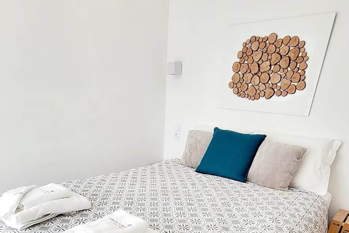 Petite chambre d'hôtes confortable et cosy avec décoration murale en bois naturel.