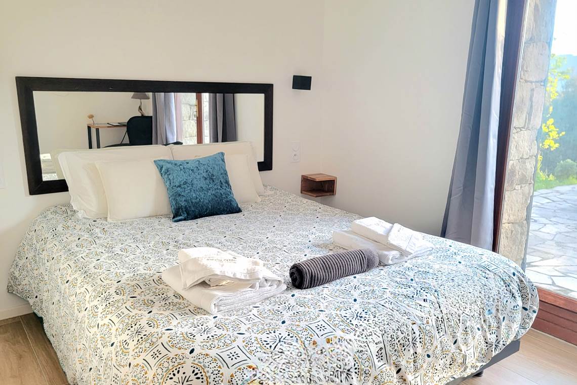Chambre d'hôtes n°4 lumineuse avec lit queen size et accès direct à une terrasse privée.
