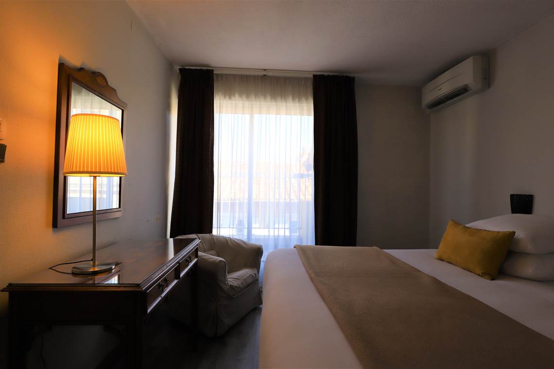 Chambre avec grand lit et balcon